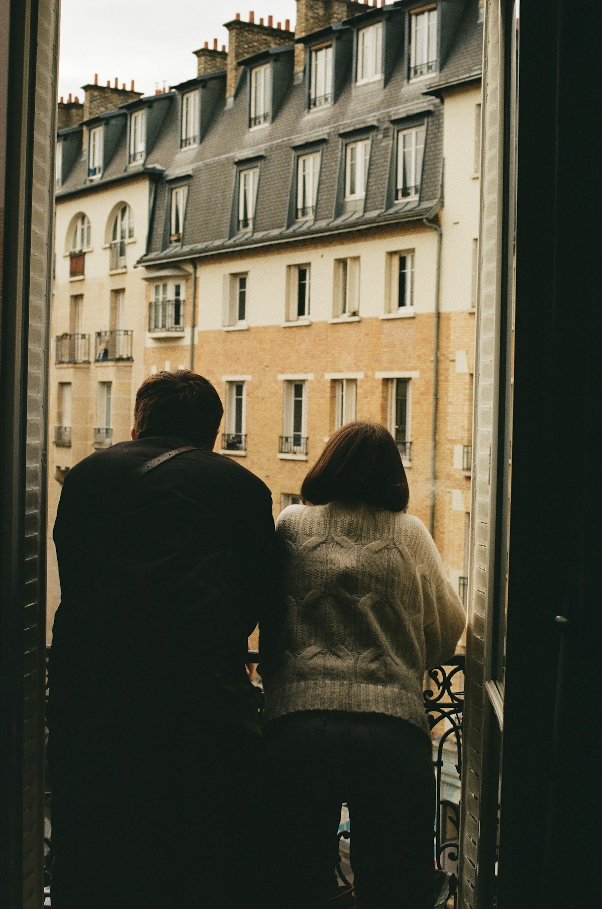 Un couple de dos devant une fenêtre